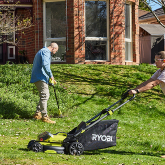 A couple using their Ryobi products in the front garden