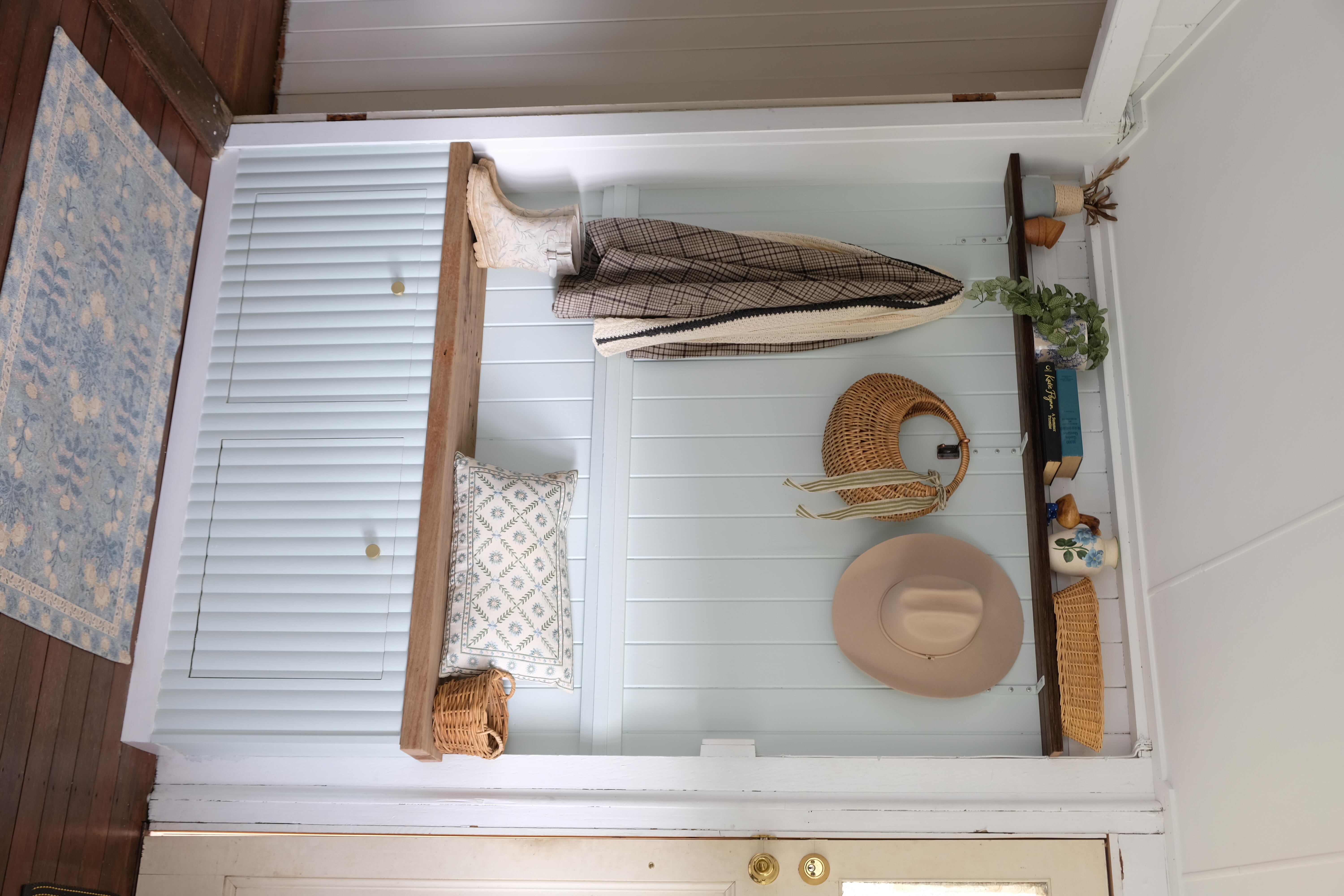 A tidy entryway with a bench and DIY shoe cabinet for additional storage. Above the seat is a shelf and coat rack to hold hats, bags and jackets.