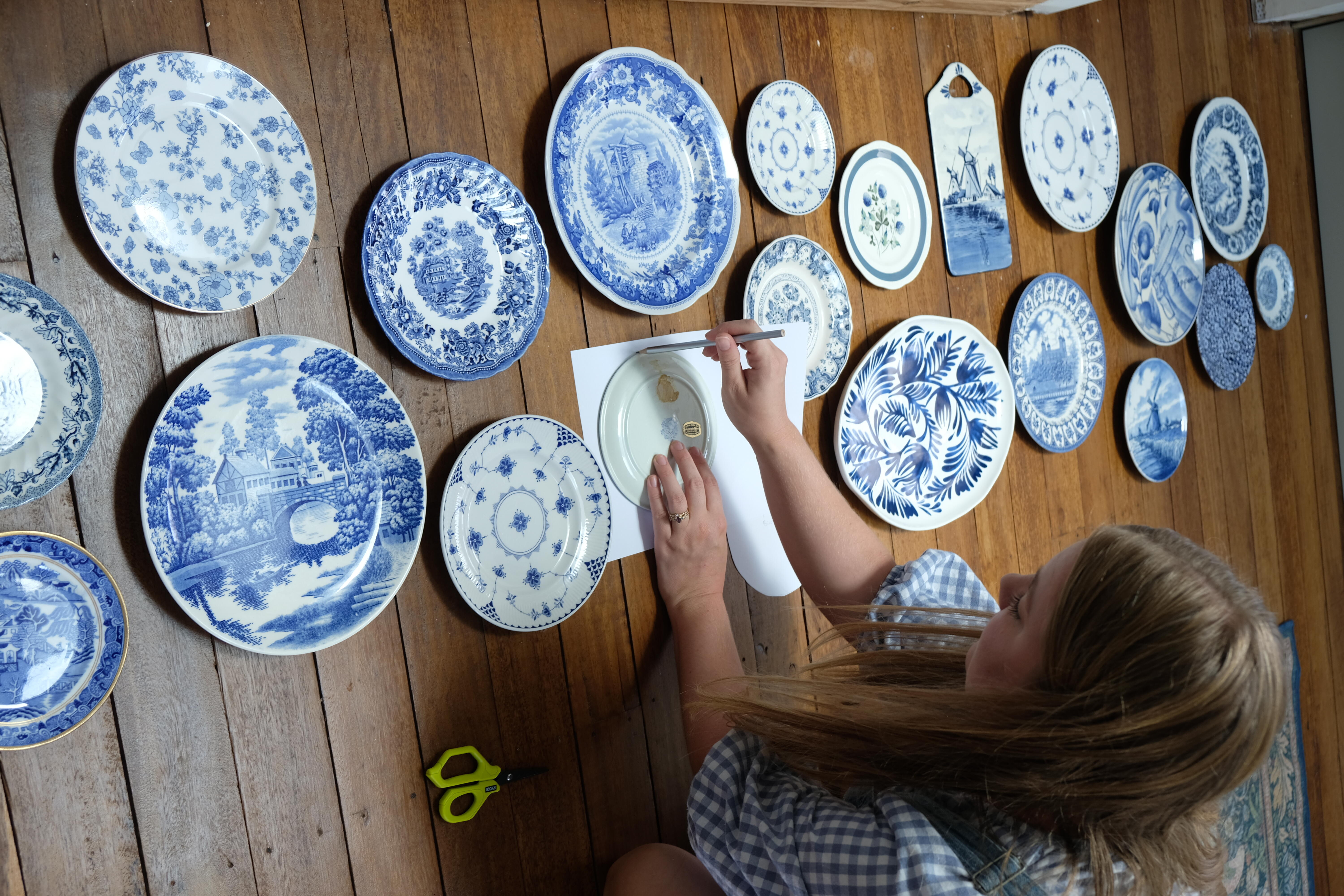 Brooke traces the outline of each plate to create a paper guide. 